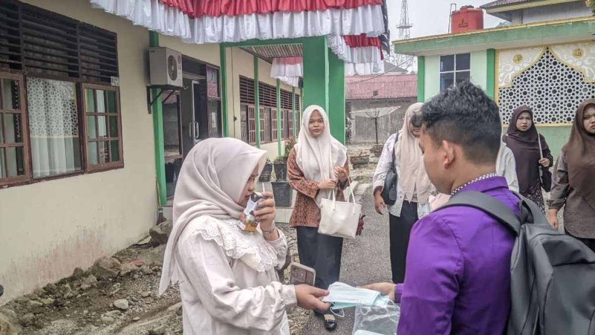 Mahasiswa HMPS PAI STAI YDI Lubuk Sikaping membagikan masker gratis kepada pengguna jalan di Pasaman akibat kabut asap.
